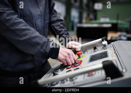 Close-up of engineer working at machine in industrial factory Stock Photo