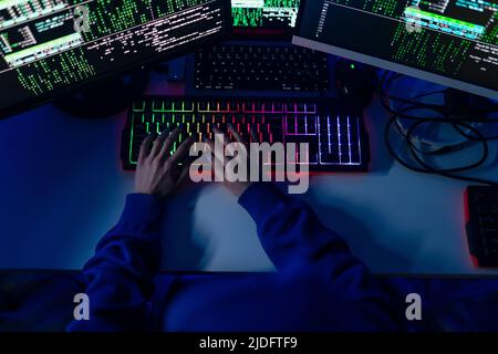 Close-up of woman hacker hands at keyboard computer in the dark room at night, cyberwar concept. Top view. Stock Photo