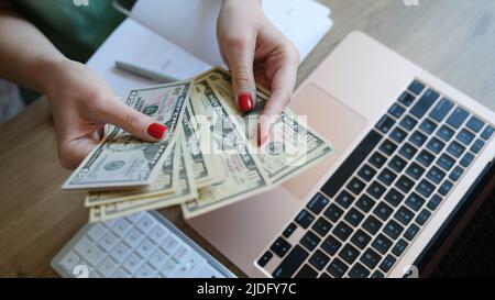 Female holding cash in hand and counting banknotes Stock Photo