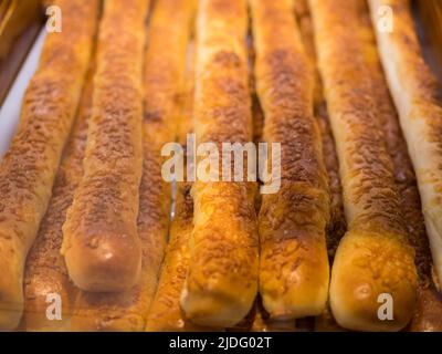 Close-up view of the chesse stick breads on a tray and selling in the bakery shop. Stock Photo