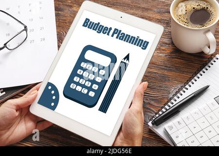 Young woman using tablet computer in office, closeup. Budget planning Stock Photo