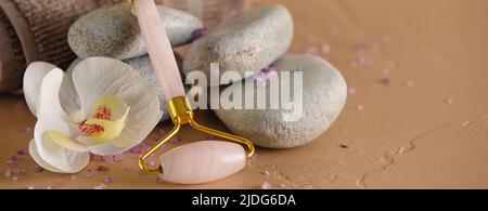 Facial massage tool, spa stones and flower on table, closeup Stock Photo