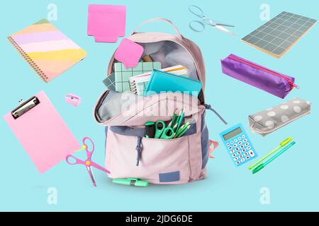 School backpack and different stationery on light blue background Stock Photo
