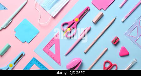 Different school supplies and medical mask on colorful background, top view Stock Photo