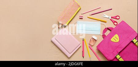 Different school supplies and medical mask on color background with space for text, top view Stock Photo