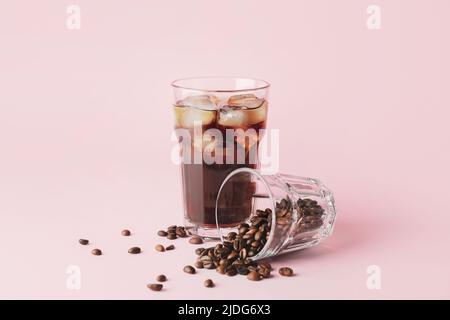 Glasses with cold brew and coffee beans on pink background Stock Photo