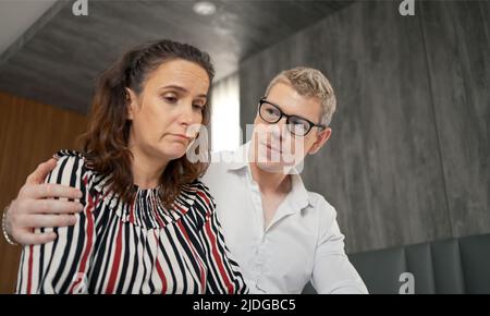 Husband consoles her tragic wife with depression in the bedroom, the wife and husband try to solve the difficult problems in life. Stock Photo