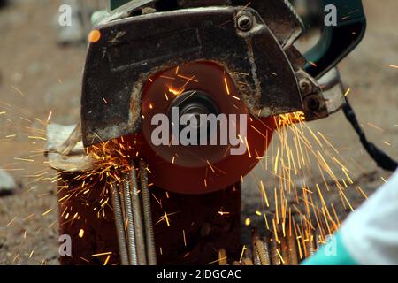 a worker cutting iron rods on construction site Stock Photo - Alamy