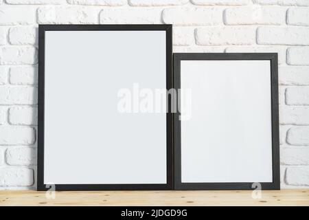 Photo frames on floor over white brick wall Stock Photo