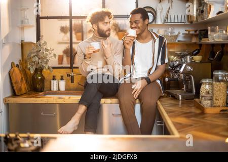Two men talking and drinking coffee on kitchen at home Stock Photo