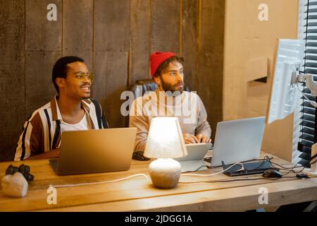 Two men working on computer at home office Stock Photo
