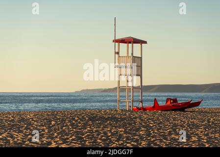 Salvataggio lifeguard watchtower and lifeboat on the sandy beach of Piscinas dunes in the golden light at sunset, Costa Verde, Sardinia, Italy Stock Photo