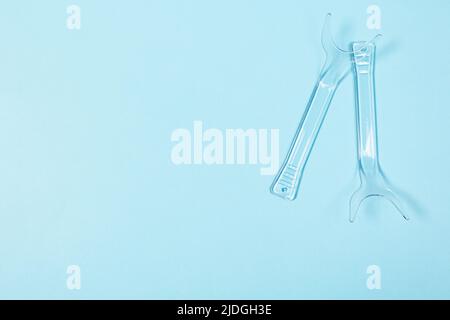 set of several Retractor Dental lip retractor Access to the oral cavity. Wide mouth opening for a dental procedure on a blue background Stock Photo