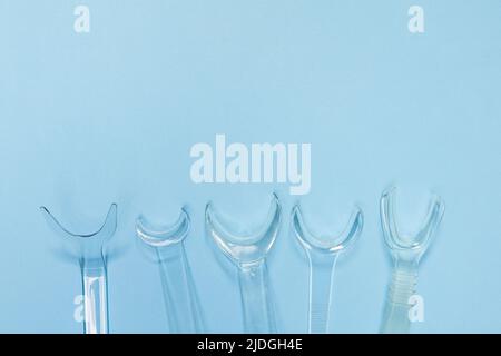 set of several Retractor Dental lip retractor Access to the oral cavity. Wide mouth opening for a dental procedure on a blue background Stock Photo