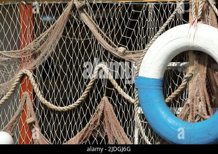 old life belt or buoy and fishing net, nautical themed decoration Stock  Photo - Alamy