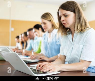 Side view of group of adult students in university classroom Stock Photo