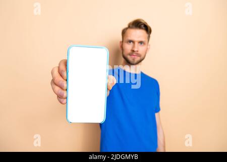 Portrait of calm focused person hold demonstrate empty space display isolated on beige color background Stock Photo