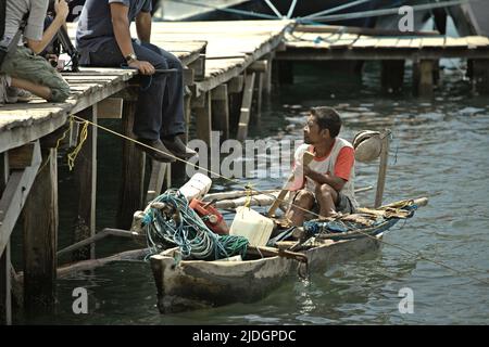 A fisherman talking to journalists from his boat during a media trip in Loh Buaya in Rinca Island, a part of Komodo National Park in Komodo, West Manggarai, East Nusa Tenggara, Indonesia. Stock Photo