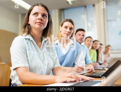 Group of attentive students writes synopsis in copybooks Stock Photo