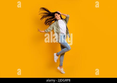 Full size portrait of active overjoyed girl jumping raise fists empty ...