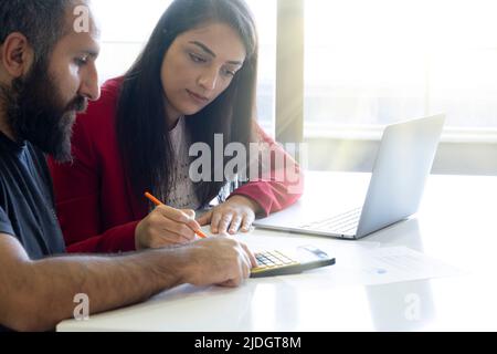 Working together, business partnership coworkers working together. Analysing graphics of financial reports. Calculating budget, planning future. Stock Photo