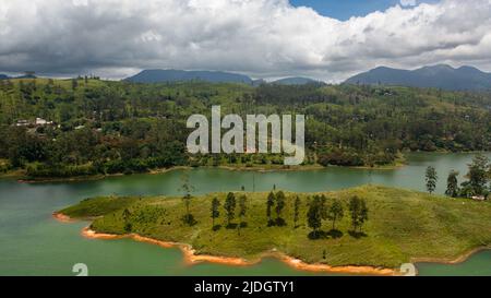 Hills with tea plantations around the lake in the mountains. Maskeliya, Castlereigh, Sri Lanka. Stock Photo