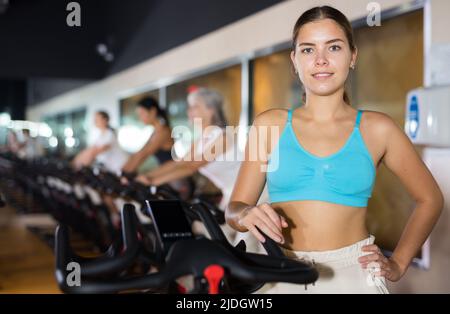 Young girl on training using bike in gym Stock Photo