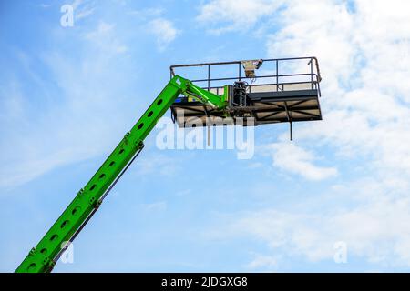 Forklift basket, industrial equipment from low angle view against blue sky Stock Photo