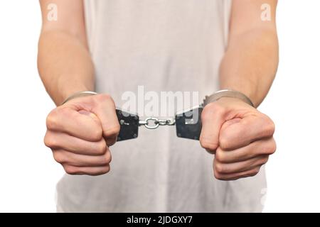 Handcuffs on the hands of a man breaking a paper wall Stock Photo - Alamy