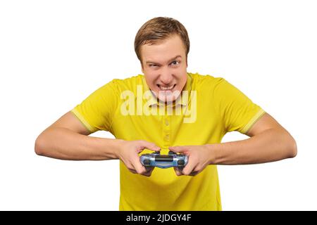 Funny attractive gamer in yellow T-shirt with gamepad isolated on white background. Cheerful young guy holding joy stick and playing videogames on TV, Stock Photo