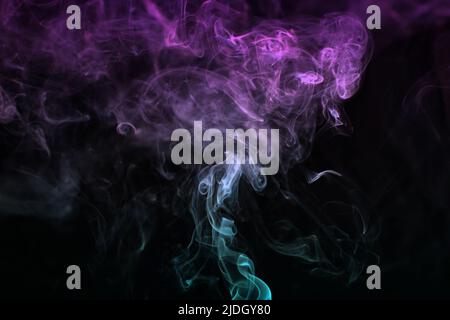Multicolored smoke for aromatherapy and relaxation on black background, beautiful swirled puffs of smoke. Pink, purple and turquoise gradient colors o Stock Photo