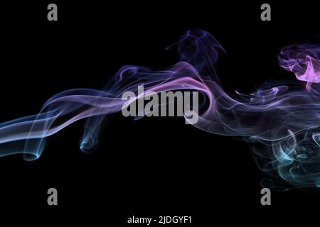 Multicolored smoke for aromatherapy and relaxation on black background, beautiful swirled puffs of smoke. Pink, purple and turquoise gradient colors o Stock Photo