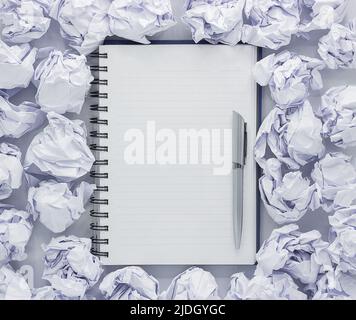 White note pad on white background. Around the notepads lies lot crumpled paper,Copy space Stock Photo