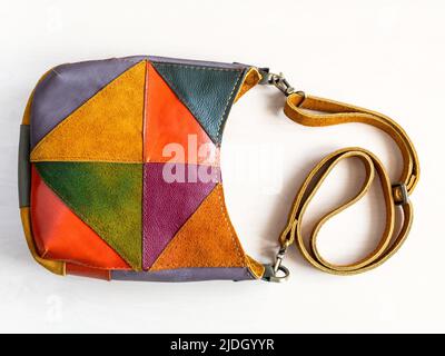 handmade patchwork crossbody bag hand sewn from suede and leather on white background Stock Photo