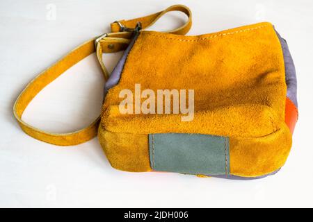 bottom view of handcrafted cross body bag hand sewn from yellow suede on white background Stock Photo