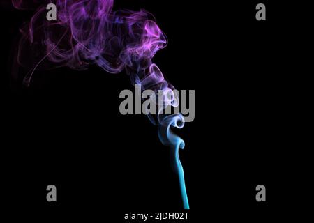 Multicolored smoke for aromatherapy and relaxation on black background, beautiful swirled puffs of smoke. Pink, purple and turquoise gradient colors o Stock Photo