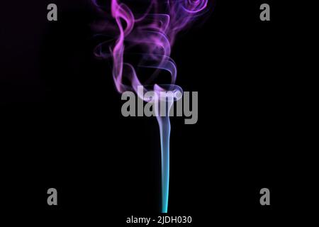 Multicolored smoke for aromatherapy and relaxation on black background, beautiful swirled puffs of smoke. Pink, purple and turquoise gradient colors o Stock Photo