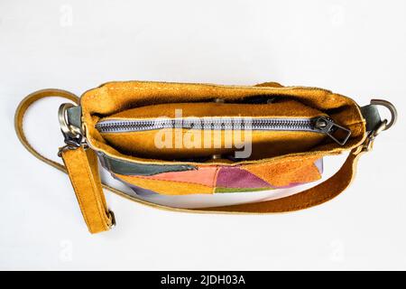 top view of closed handcrafted cross body bag hand sewn from yellow suede on white background Stock Photo