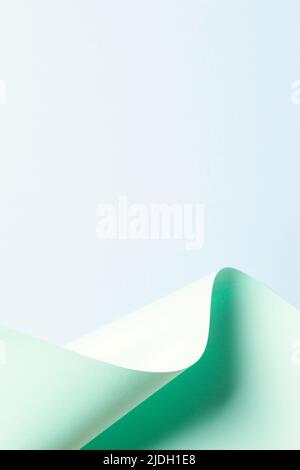 Abstract wave of pastel green paper on light blue background. Creative geometric curved paper with light and shadows. Abstract geometry background Stock Photo