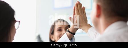 Colleagues give high five after successful agreement with partners Stock Photo