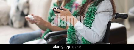 Young women playing video game for fun using controlling joystick Stock Photo