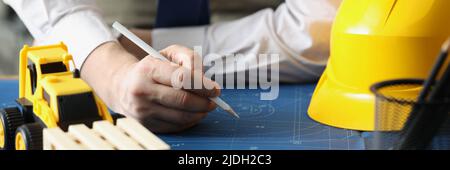 Male worker making corrections in construction planning with pencil Stock Photo