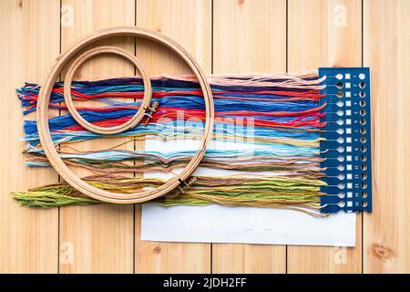 above view of embroidery kit with mouline and wood hoops on wooden planks Stock Photo
