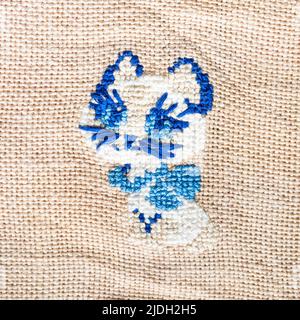 blue kitten embroidered by hand on fabric close up Stock Photo