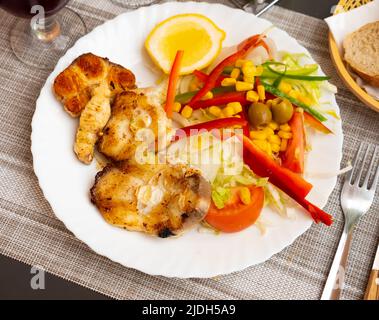 Oven baked hake with vegetable garnish Stock Photo