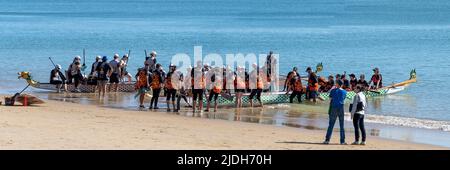 Teams on a sandy beach preparing to compete in a Dragon Boat race. Scarness Hervey Bay Queensland Australia Stock Photo