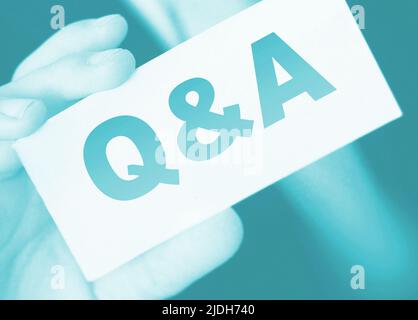 Q and A Questions and Answers sign on business card shown by a businessman,. Business concept. Stock Photo