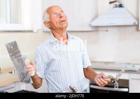 Man determining scope of plastering works Stock Photo