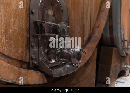 Stacked wooden barrels in a wine cellar, production and aging red wine in the traditional way Stock Photo