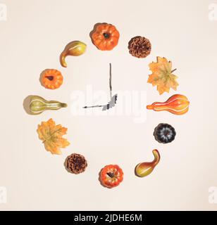 Creative autumn clock made of colorful autumn leaves, pumpkins and pinecones. Nature mockup background. Seasonal concept. Flat lay wreath. Autumn time Stock Photo